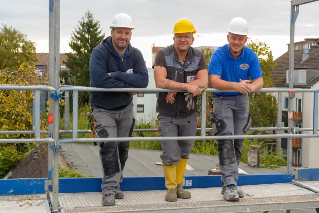 Drei Bauarbeiter auf einem Gerüst