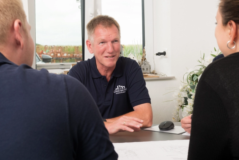 Zwei Personen, die sich von einer dritten Person beraten lassen.