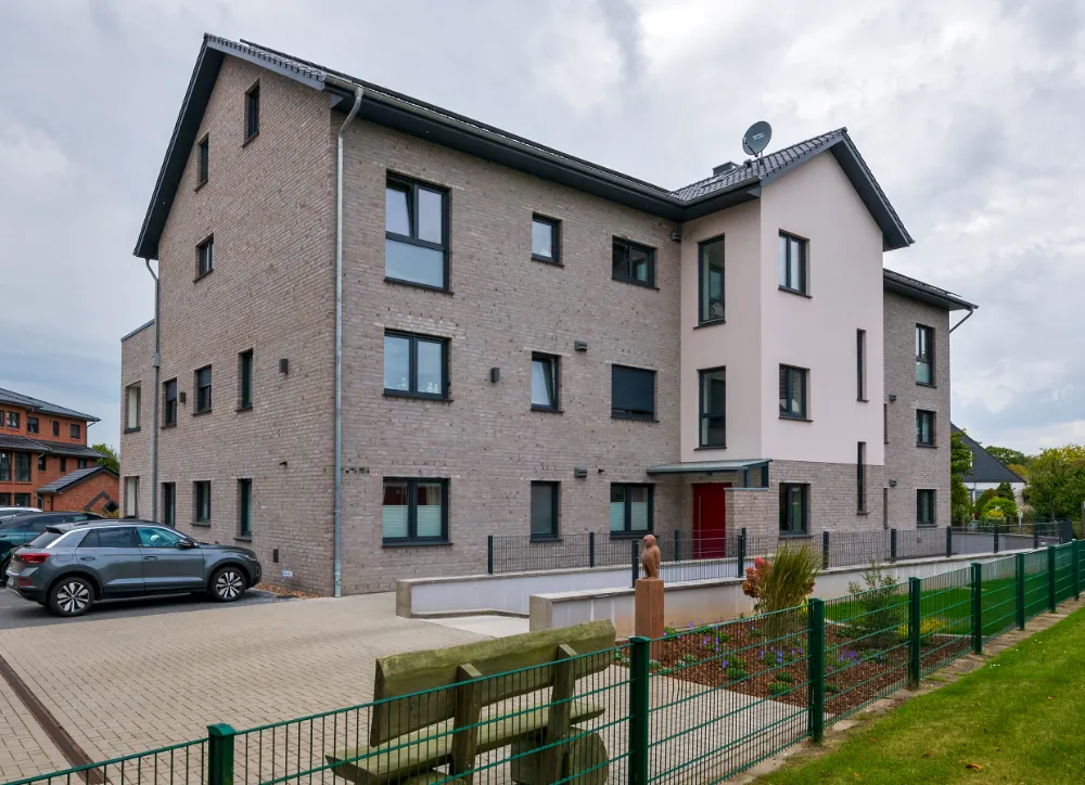 Ein Mehrfamilienhaus mit Parkplatz und Tiefgarage