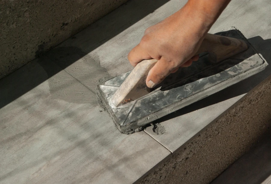 Ein Fliesenleger schließt eine Fuge.