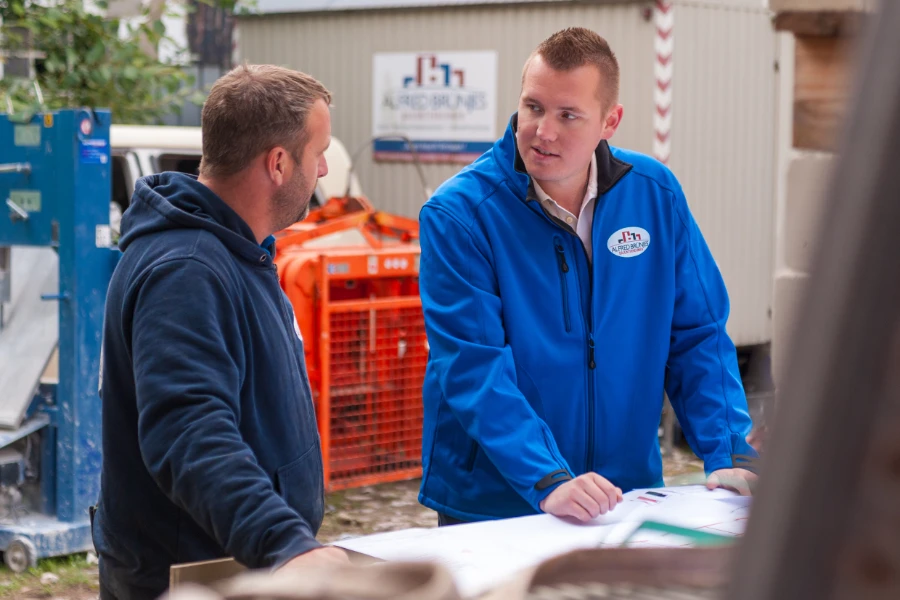 Zwei Mitarbeiter besprechen den Bauplan