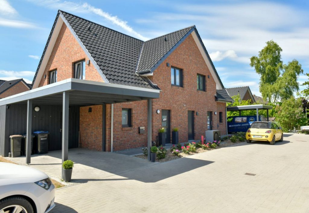 Ein Einfamilienhaus mit überdachtem Parkplatz