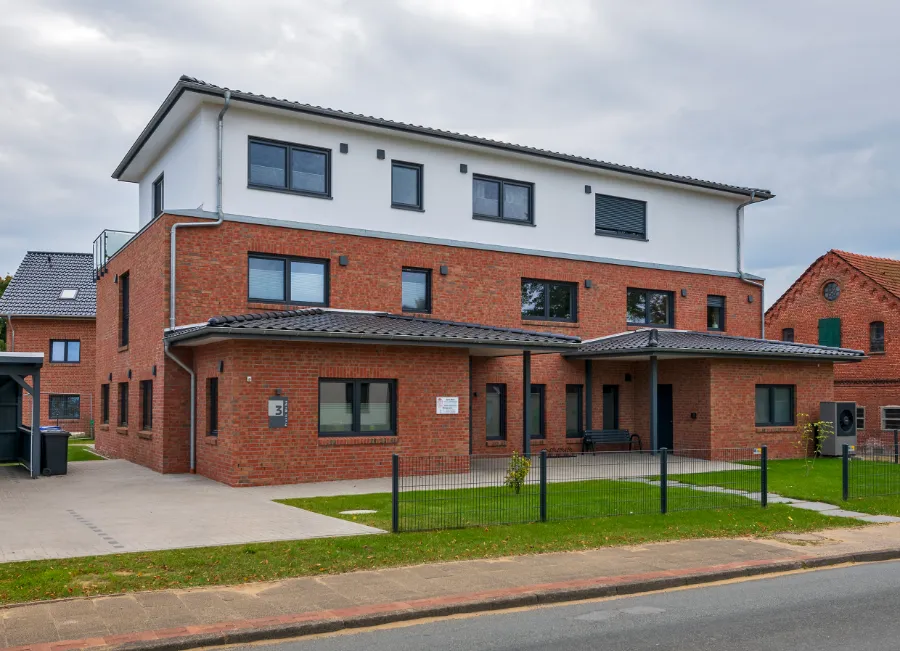 Ein Mehrfamilienhaus mit einer medizinischen Einrichtung im Erdgeschoss.