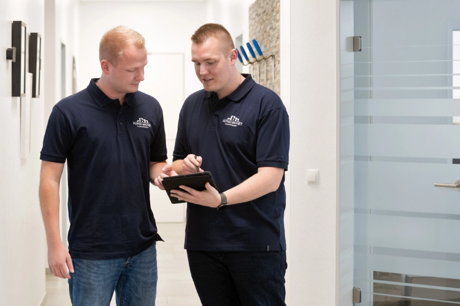 Zwei Angestellte der Firma besprechen etwas auf einem Tablet.