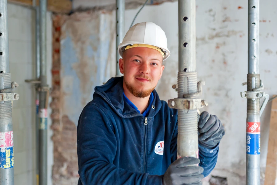 Ein Mitarbeiter der Firma sichert ein Gerüst.