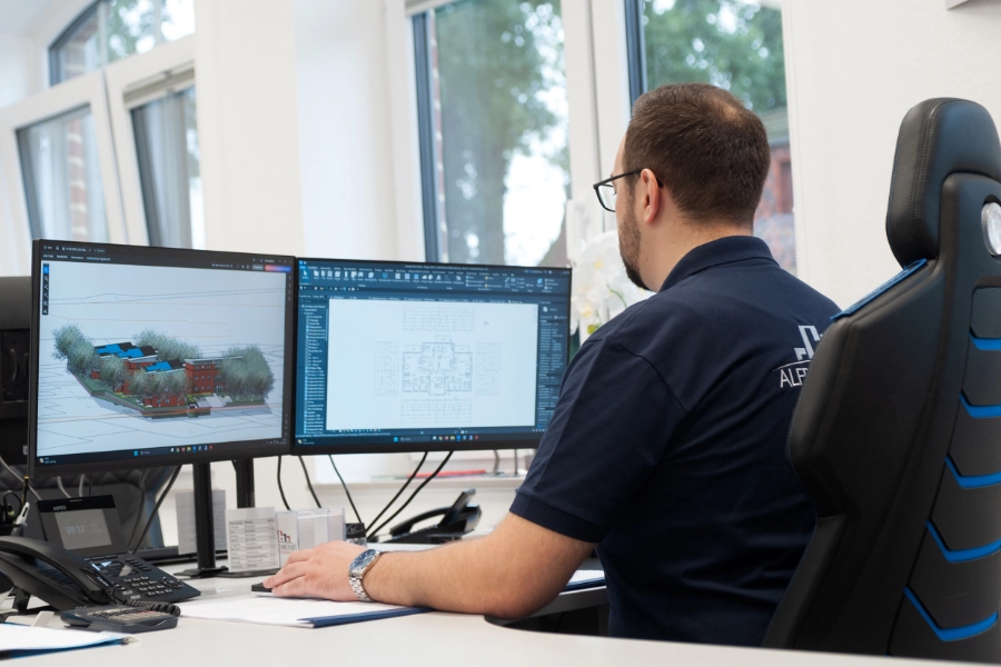 Ein Mann arbeitet am Computer an eine, 3D Render eines Bauvorhabens.