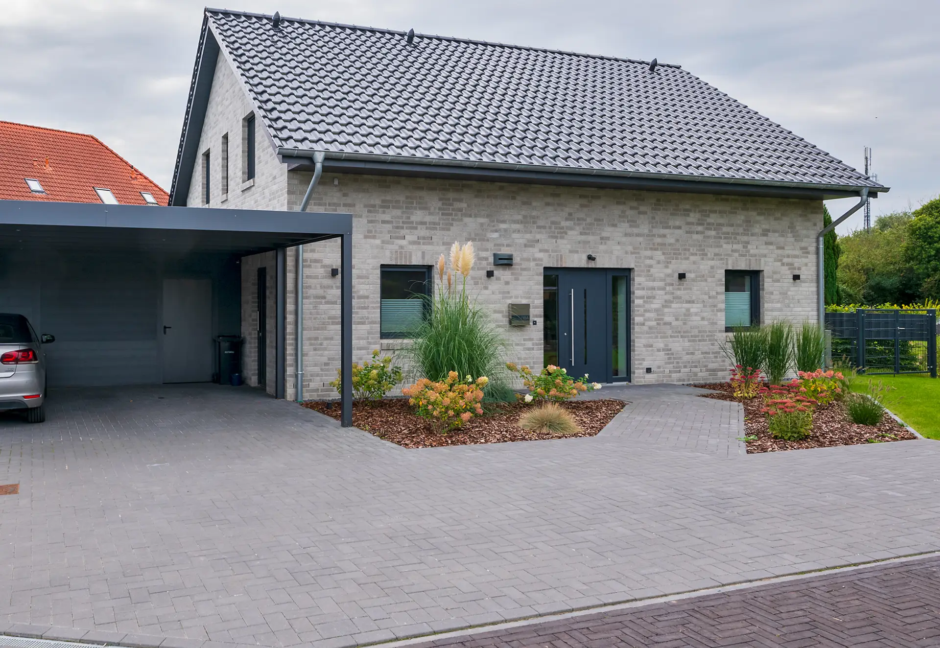 Ein modernes Einfamilienhaus mit überdachtem Parkplatz mit zwei Stellplätzen.