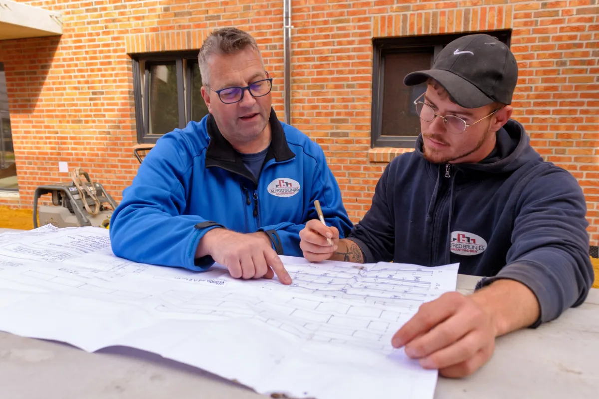 Zwei Mitarbeiter besprechen einen Bauplan
